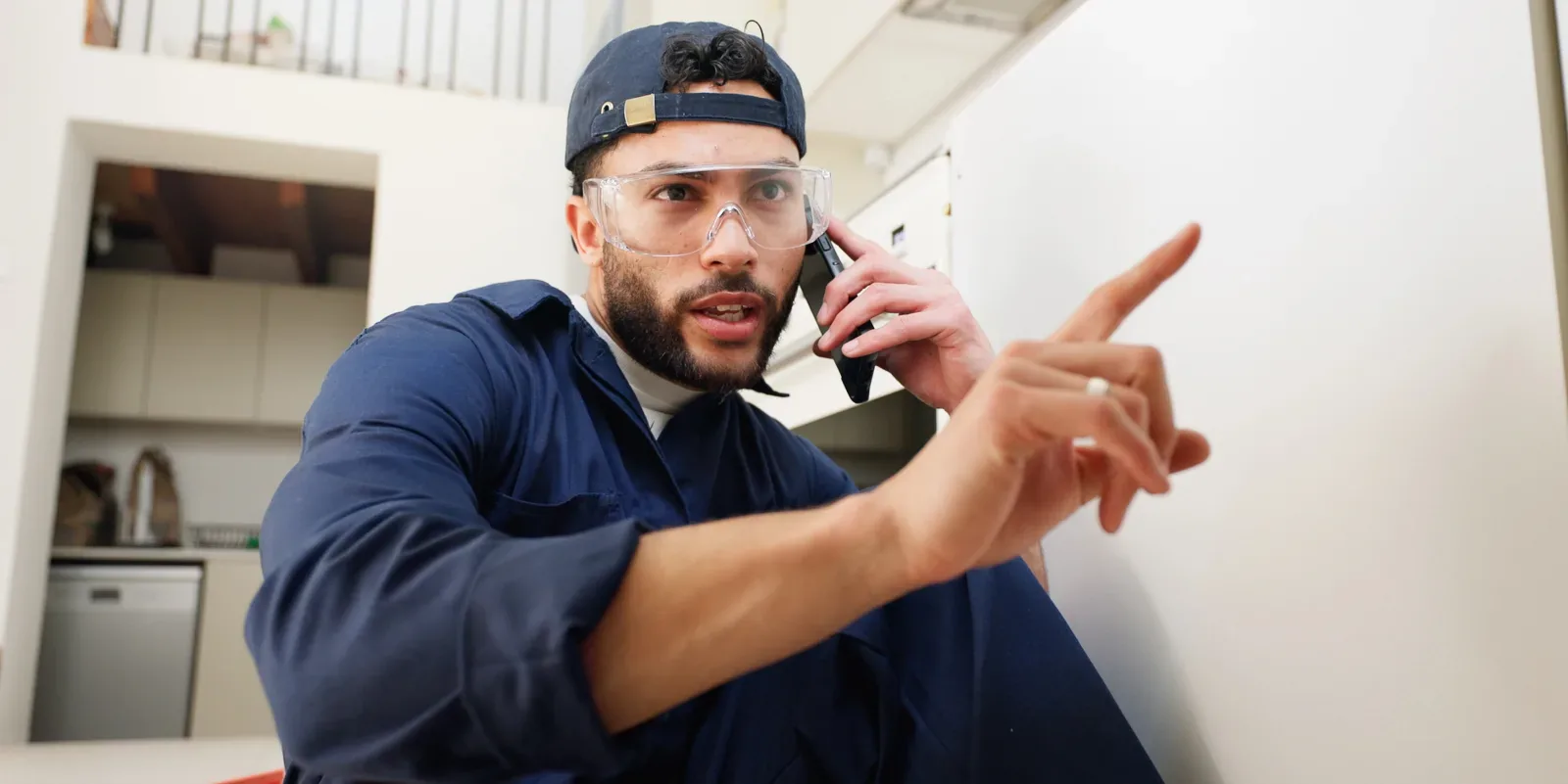 Plombier de l'équipe Allô Panne au téléphone pour une urgence de canalisation